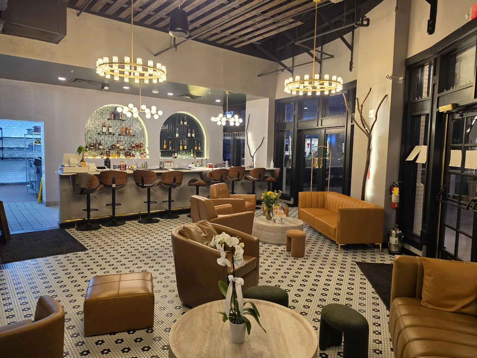 Inju Sterling’s welcoming lounge with warm chandeliers, green tile and leather seating